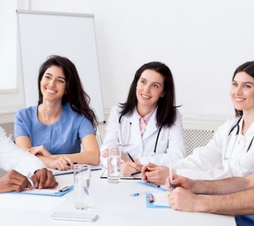 Young interns listening to professor in conference room in hospital
